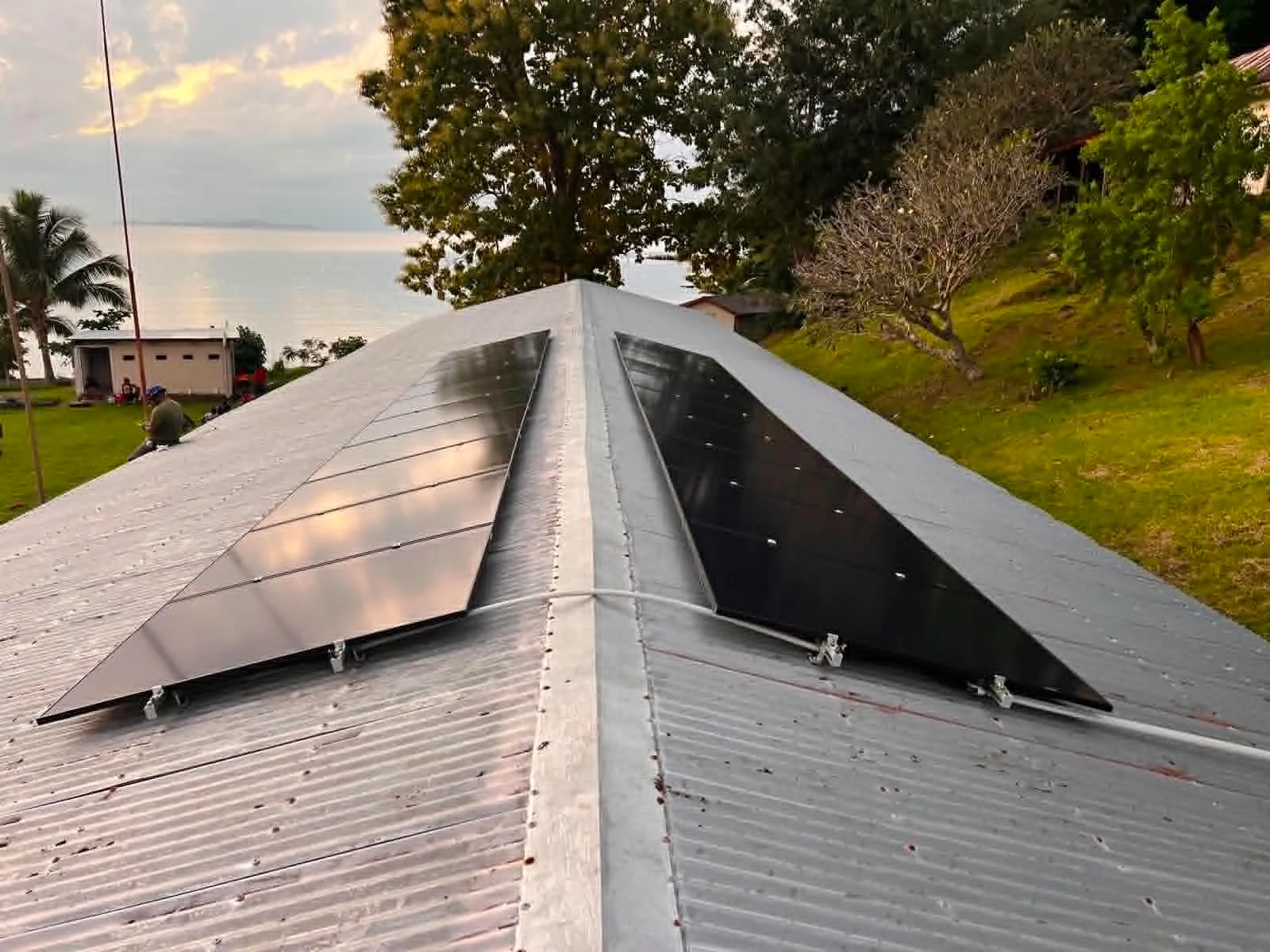 All-black solar panels installed on a Fijian hip roof overlooking the sea